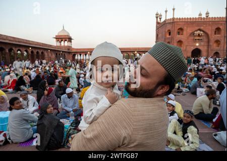 Nuova Delhi, India. 17 marzo 2024. Un uomo musulmano, porta suo figlio mentre aspetta il tramonto per rompere il digiuno del Ramadan alla moschea Jama Masjid. (Foto di Pradeep Gaur/SOPA Images/Sipa USA) credito: SIPA USA/Alamy Live News Foto Stock