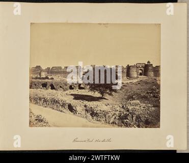 Ha rovinato Fort. Vecchia Delhi. John Edward Saché, fotografo (prussiano o britannico, nato Prussia, 1824 - 1882) 1864–1868 veduta del complesso fortificato di Purana Qila o del vecchio forte, visto da lontano. Il forte è in uno stato di rovine con detriti sparsi in primo piano. La Bara Darwaza, a volte chiamata porta Ovest, è visibile nell'area centrale destra dell'immagine con un chattri o un padiglione decorativo a cupola su una delle sue torri. (Recto, stampa) in alto a sinistra, in inchiostro marrone: '24.'; in basso al centro, inciso in negativo: '117'; (Recto, Mount) in basso al centro, in inchiostro marrone: 'Ruined Fort. Foto Stock