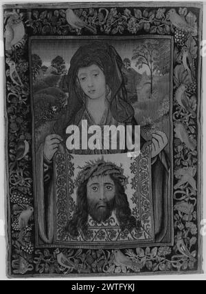 St Veronica che tiene "Sudarium" (velo con immagine di Cristo). Sconosciuto c. 1515-1525 arazzi dimensioni: H 31 1/4' x W 23' arazzo materiali/tecniche: Sconosciuto Cultura: Sud dei Paesi Bassi tessitura Centro: Sconosciuta storia di proprietà: French & Co. Ricevuto da Durlacher (per il resoconto della Galleria d'Arte spagnola), 21/11/1942; restituito, 4/10/1943. Mezza figura di St. Veronica regge la "vera icona" con Cristo che indossa la corona di spine; paesaggio sullo sfondo (BRD) viti tortuose legate con nastri intervallati da uccelli e grappoli di uva probabilmente tessuti a Bruxelles (Cavallo). Si vede GCPA 0244527 Foto Stock