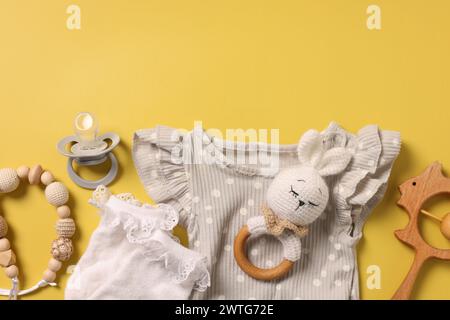 Diversi accessori per bambini su sfondo giallo, con disposizione piatta. Spazio per il testo Foto Stock