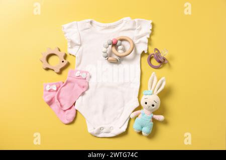 Diversi accessori per bambini su sfondo giallo, con disposizione piatta Foto Stock