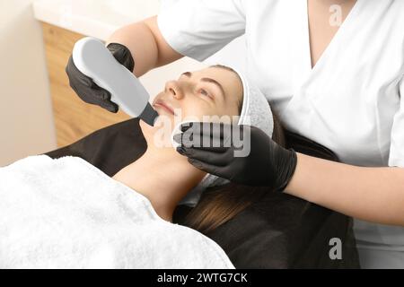 Cosmetologo che utilizza lo scrubber a ultrasuoni, primo piano. Cliente con procedura di pulizia in clinica Foto Stock