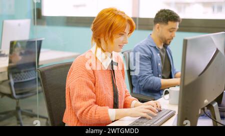 Colleghi che lavorano felicemente insieme in uno spazio di coworking Foto Stock