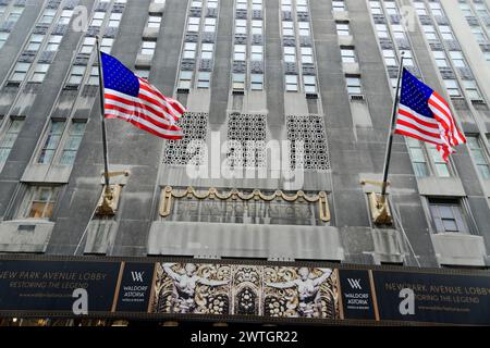 Hotel di lusso Waldorf Astoria sulla Fifth Avenue, Midtown, entrata alla famosa facciata dell'hotel con due bandiere americane e decorazioni ondulate, Manhattan, New Foto Stock