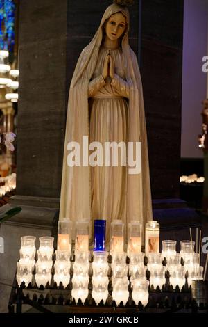 St Paul the Apostle Church di New York, statua della Vergine Maria in preghiera, circondata da molte scintillanti lume di candela, Manhattan, New York City, New York Foto Stock