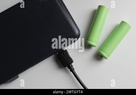 Fonti di energia elettrica portatili. Batterie ricaricabili vicine al Powerbank carico isolate sulla vista dall'alto bianca Foto Stock