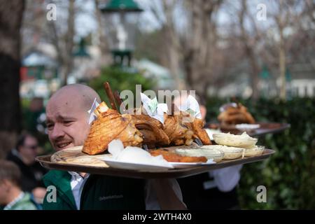 AUSTRIA; VIENNA; 20240315; i camerieri portano i tableaux con l'originale "Schweizerhaus Stelze" (palafitte della casa svizzera) attraverso la birreria all'aperto del famoso ristorante Schweizerhaus nel parco divertimenti Prater di Vienna durante la stagione di apertura a Vienna il 15 marzo 2024. Il ristorante Schweizerhaus è famoso per le sue palafitte di maiale e la birra Budweiser. - 20240315 PD16990 credito: APA-PictureDesk/Alamy Live News Foto Stock