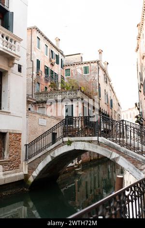 Tranquillo canale veneziano con ponte ad arco Foto Stock