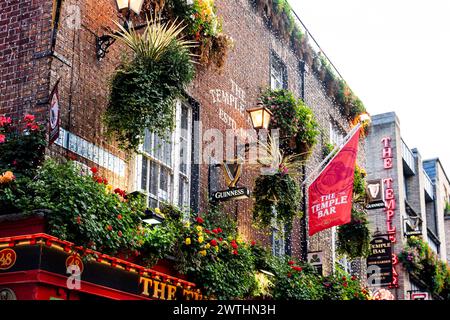 La pittoresca parete del famoso Temple Bar Pub su Temple Lane, con fiori e un cartello Guinness vintage, Temple Bar District, Dublino Foto Stock