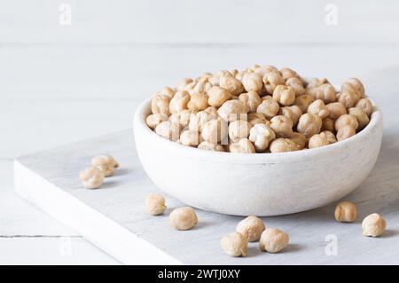 Ceci secchi crudi nel recipiente o cucchiaio sul tavolo. Un mucchio di ceci leguminosi Foto Stock