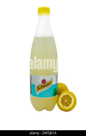 Odessa, Ucraina, 18 marzo 2024: Bottiglia di vetro di Schweppes su fondo isolato e due limoni, uno in taglio Foto Stock