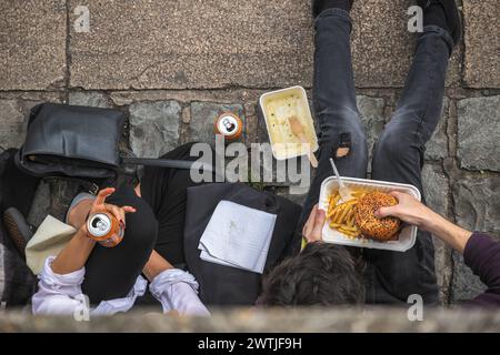 Vista dall'alto di due persone che mangiano da asporto in strada al Camden Market Foto Stock