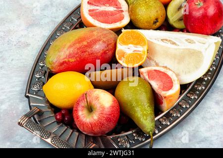 Mele, pere, manghi e agrumi su un elegante vassoio Foto Stock