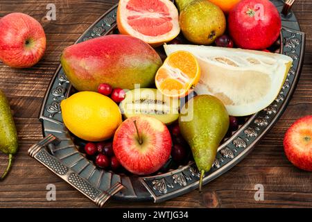 Mele, pere, manghi e agrumi su un elegante vassoio Natura morta con frutta fresca. Foto Stock