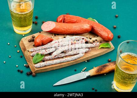 Salsicce kabanos affumicate e bicchiere di birra sul tagliere. Cibo dell'Oktoberfest. Foto Stock