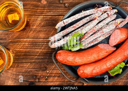 Salsicce Kabanos, salumi affumicati. Salsicce affumicate secche, salame, kabano e birra fredda su un tavolo rustico. Stuzzichini di birra appetitosi. Foto Stock