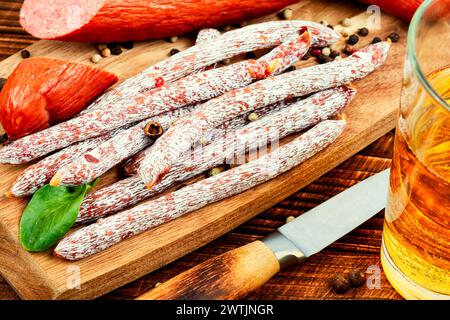 Salsicce kabanos affumicate, preparate con carne macinata mista sul tagliere. Carne di maiale o di manzo, salsiccia e birra fredda. Foto Stock