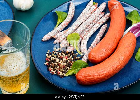 Salsicce di kabanos affumicate, preparate con macinazione mista. Salsicce affumicate secche, salame, kabano e birra fredda. Foto Stock