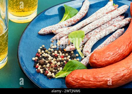 Kabani affumicati secchi, cabanossi. Cibo dell'Oktoberfest. Salsicce polacche tradizionali, bicchiere di birra. Stuzzichini di birra appetitosi. Bar o pub. Foto Stock