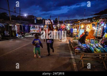 La gente del posto torna a casa dal lavoro lungo le strade trafficate di Kibera Slum, Nairobi. Kibera, il più grande slum di Nairobi e Africa, è hom Foto Stock