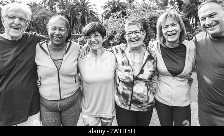 Persone anziane multirazziali divertirsi dopo l'allenamento esercizi all'aperto con parco cittadino in background - stile di vita sano e gioioso stile di vita anziano con Foto Stock