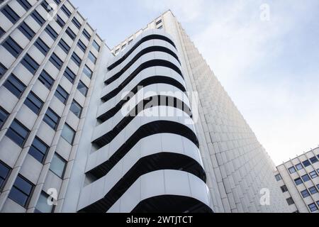 Facciata architettonica moderna di un alto edificio con balconi curvi e motivi geometrici Foto Stock