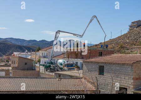 Pompa per calcestruzzo che versa calcestruzzo sul piano superiore di Una casa di nuova costruzione, Spagna Foto Stock