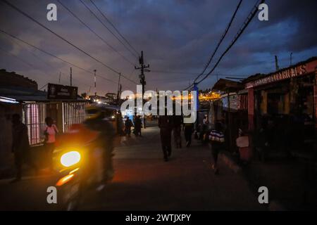 La gente del posto torna a casa dal lavoro lungo le strade trafficate di Kibera Slum, Nairobi. Kibera, il più grande slum di Nairobi e Africa, è hom Foto Stock