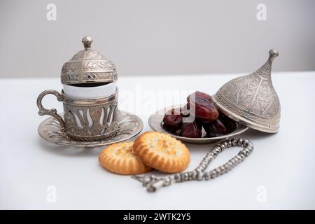 dattera il rosario dei dolci kahk eid e le tazze da caffè su sfondo bianco isolato Foto Stock