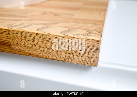 Legname incollato sotto la vernice bordo angolo tavolo top selettivo fuoco macro primo piano. Interni del bagno dal design contemporaneo, piano superiore Foto Stock