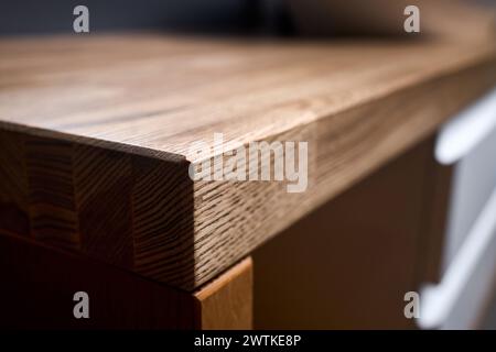 Legname incollato sotto la vernice bordo angolo tavolo top selettivo fuoco macro primo piano. Interni del bagno dal design contemporaneo, piano superiore Foto Stock