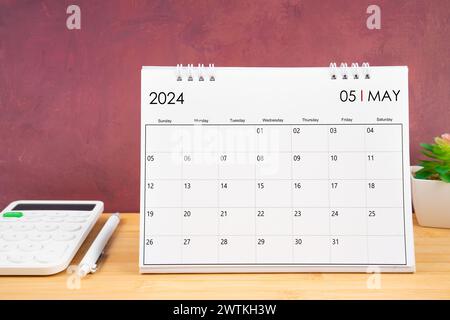 Maggio 2024 calendario bianco e calcolatrice con penna sul tavolo. Foto Stock