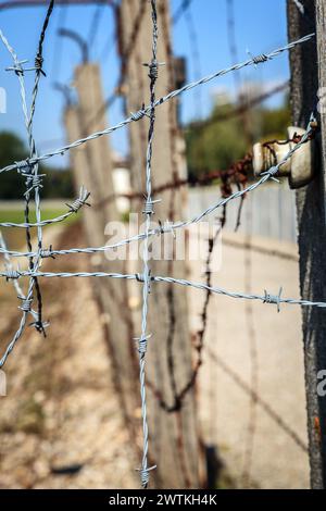 Dachau, Germania, 30 settembre 2015: Immagine ravvicinata del filo spinato della recinzione perimetrale del campo di concentramento di Dachau in Germania Foto Stock