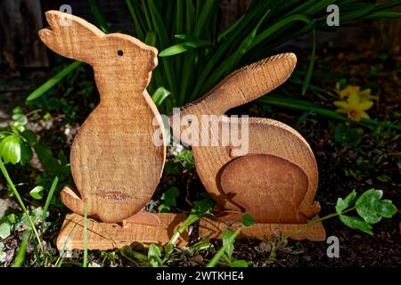 Zwei hübsche Holzhasen im Gras als Osterdekoration Foto Stock