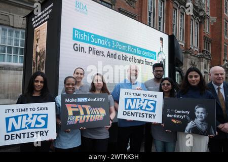 Londra, Regno Unito. 18 marzo 2024. Un gruppo di dentisti si riunisce a Whitehall per esprimere le loro preoccupazioni sullo stato delle cure dentistiche del sistema sanitario nazionale. La protesta, organizzata da professionisti dentali, mira a far luce sulle gravi sfide che il settore deve affrontare. I partecipanti devono condividere storie strazianti di pazienti costretti a eseguire autoestrazioni a causa della mancanza di servizi odontoiatrici accessibili. La dimostrazione cerca di sollecitare l'azione del governo per riforme sostanziali volte a migliorare l'assistenza dentale del sistema sanitario nazionale. Crediti: Joao Daniel Pereira/Alamy Live News Foto Stock