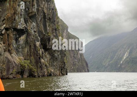 Parte dello spettacolare Milford Sound, uno dei luoghi più umidi del pianeta, è visto sotto un cielo tipicamente pesante sopra Fiordland, nuova Zelanda. Foto Stock