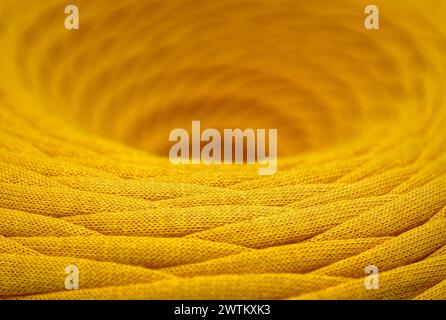 Spilla di cordone sintetico intrecciato giallo, primo piano, messa a fuoco selettiva, background astratto del settore tessile Foto Stock