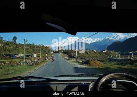 Vista naturale del crinale innevato di Machhapuchhre e dell'Annapurna nella catena montuosa dell'Himalaya dallo scudo anteriore per auto di Pokhara, Nepal Foto Stock