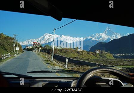 Vista naturale del crinale innevato di Machhapuchhre e dell'Annapurna nella catena montuosa dell'Himalaya dallo scudo anteriore per auto di Pokhara, Nepal Foto Stock