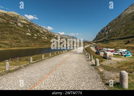 Old Gotthard Pass Road Old Gotthard Pass Road con ciottoli, lago e piccolo campeggio con camper Foto Stock