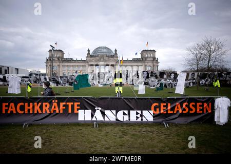 Long Covid Awareness Day DEU, Deutschland, Germania, Berlino, 15.03.2024 Transparent 100000 Fachkraefte Haengen Hängen gelassen der Initiative NichtGenesen gegen die Folgen von Covid Corona und der Forderung Wir forschen Forschung unter dem motto nicht Genesen Wir Leiden Wir Sterben Sie schauen Zu beim dritten Internationaler Long Covid Awareness Day vor dem Reichstag Sitz Deutcher Bundestag in Berlino Germania . Protesta gegen das Leiden vieler Menschen von Long Covid und mehr biomedizinische Forschung um Post-Covid, ME/CFS und Post-Vac . MIT 500 Portraits von Menschen, die aufgrund de Foto Stock