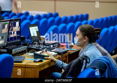 Giovane donna video editor in maschera protettiva che lavora al seminario di conferenza utilizzare il laptop editing video per lo streaming su Internet, social media Foto Stock