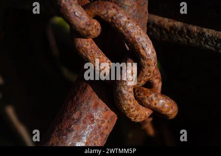 Primo piano di una catena arrugginita che fissa una vecchia macchina per motivi di sicurezza Foto Stock