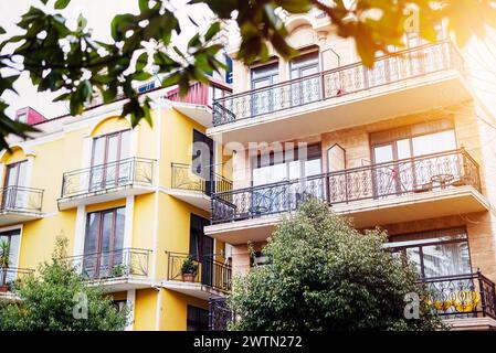 La facciata della casa con un bel balcone al sole estivo. Balcone con ringhiere in metallo. Concetto laconico minimalista. Foto Stock