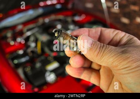Tenere a mano le candele del motore usate. Foto Stock