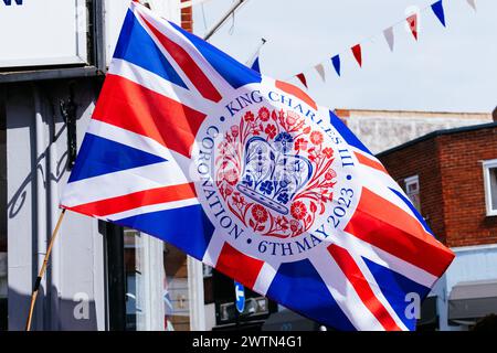 Bandiera Union Jack con logo ufficiale emblema dell'incoronazione di re Carlo III Cowes, Isola di Wight, Inghilterra, Regno Unito, Europa Foto Stock