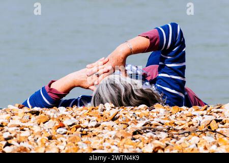 Donna sdraiata sulla spiaggia. Cowes, Isola di Wight, Inghilterra, Regno Unito, Europa Foto Stock