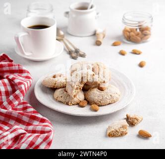 Biscotti alle mandorle, serviti con caffè su piatto su un tavolo leggero, Paste di Mandorle Foto Stock