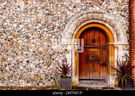 Casa dell'Arcidiaconio, con porta ad arco semicircolare e muro di selce. Chichester Cathedral, Canon Lane, Chichester, West Sussex, South East, Inghilterra, uni Foto Stock