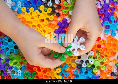 Le mani dei bambini giocano con il giocattolo colorato. Concetto di attività didattica con elementi di base Foto Stock